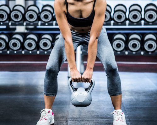fit-woman-lifting-kettlebell-at-gym-P24UMCY-min.jpg